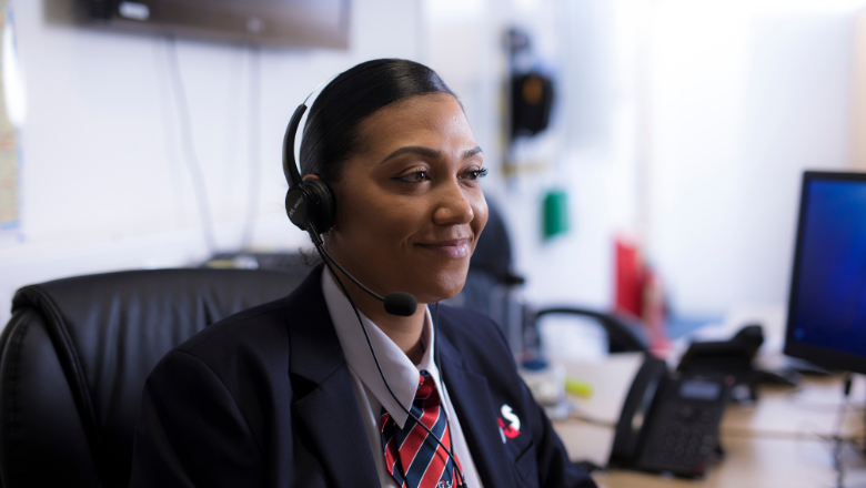 Customer support professional smiling while wearing a headset, providing assistance