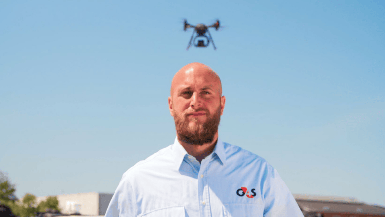 A security professional monitors a drone flying overhead